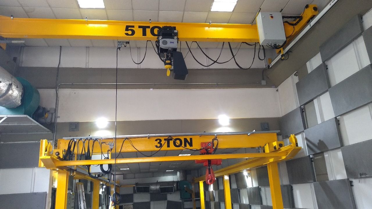 Puentes grúa de 5 y 3 toneladas en una planta, con viga amarilla y polipasto